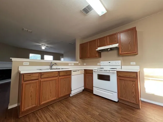 a kitchen with a white cabinets a sink and wooden floor