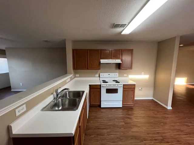 a kitchen with a sink a stove and a refrigerator