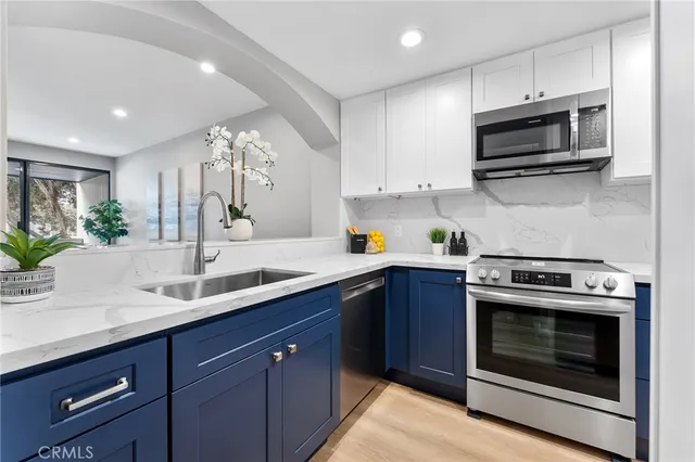 a kitchen with stainless steel appliances a stove a microwave a sink and cabinets