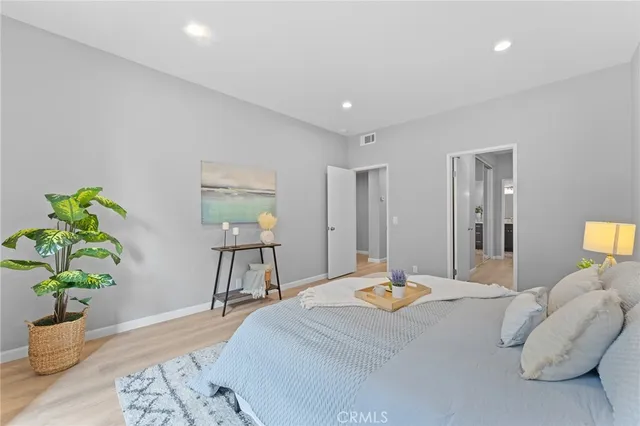 a view of a hallway with wooden floor and a bathroom