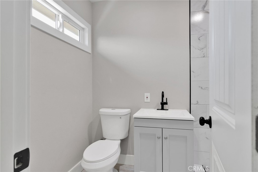 24521 Myers Avenue Moreno Valley, CA 92553 - Photo 6 of 9 a white toilet sitting next to a bathroom sink