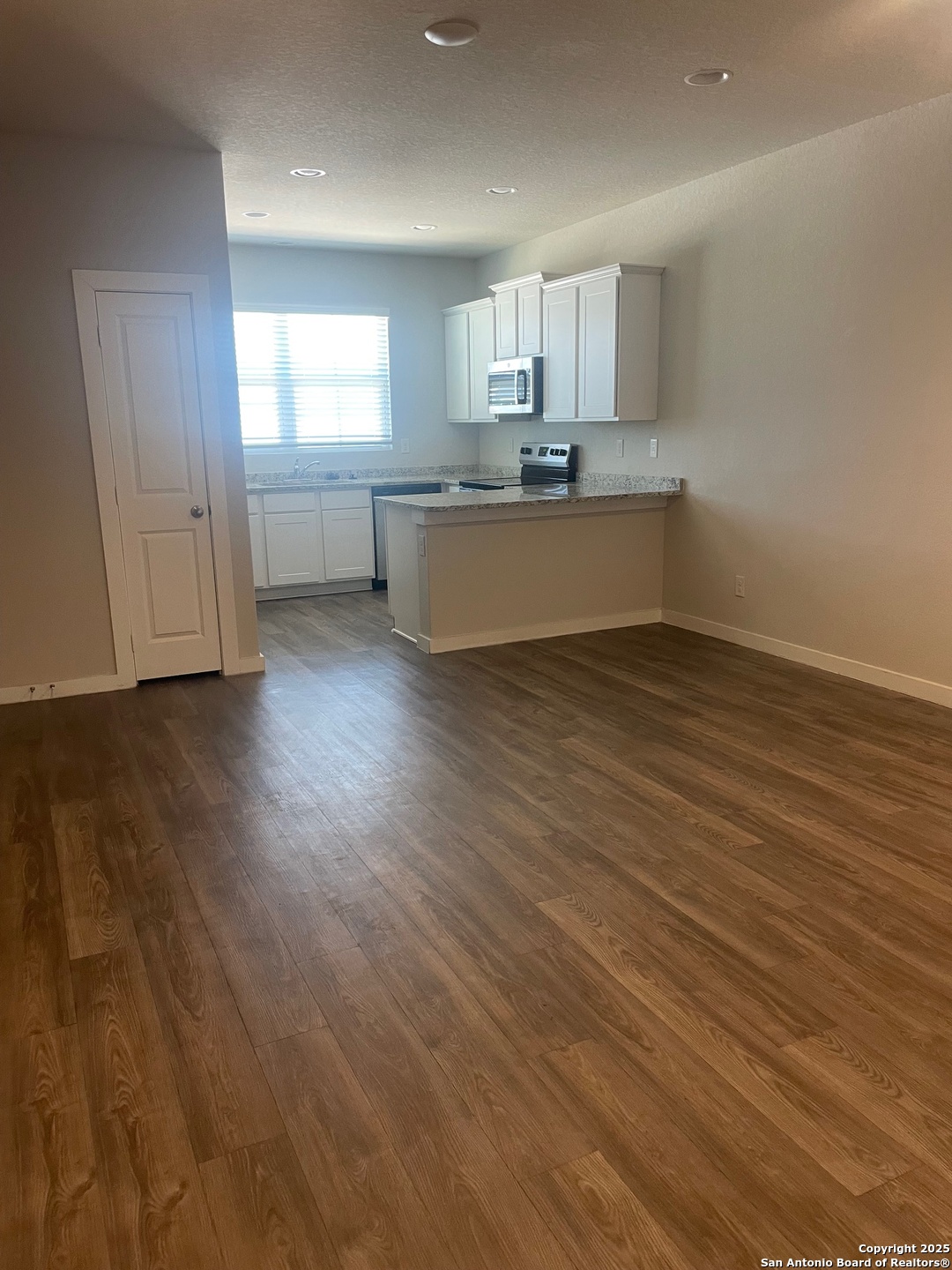 8318 Runner Cove, Unit 101 San Antonio, TX 78249 - Photo 17 of 36 a kitchen with stainless steel appliances a sink cabinets and wooden floor