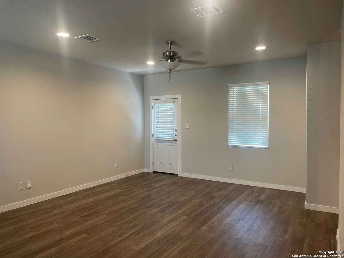 8318 Runner Cove, Unit 101 San Antonio, TX 78249 - Photo 21 of 36 an empty room with wooden floor chandelier fan and windows