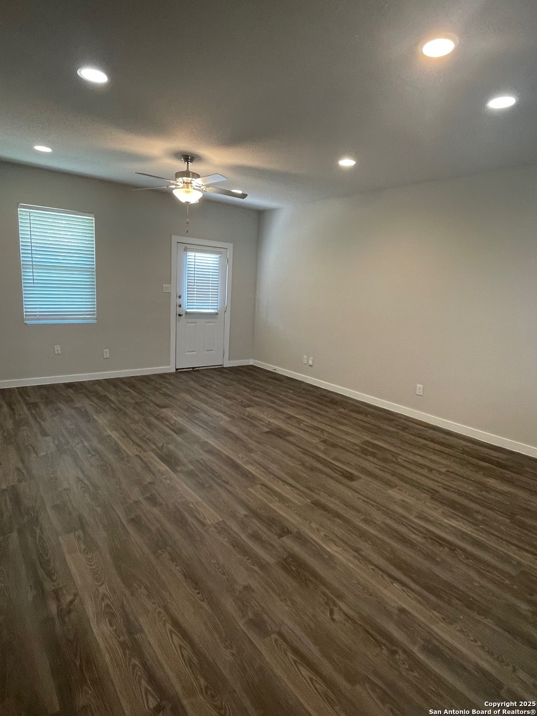 8318 Runner Cove, Unit 101 San Antonio, TX 78249 - Photo 35 of 36 an empty room with wooden floor and windows