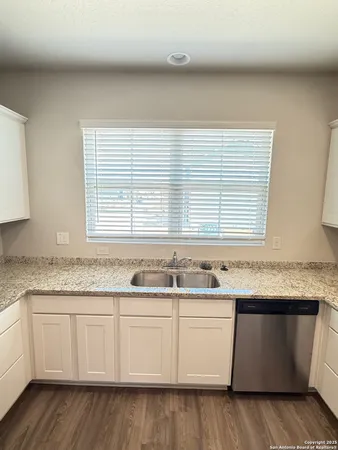 a kitchen with granite countertop kitchen island with white cabinets