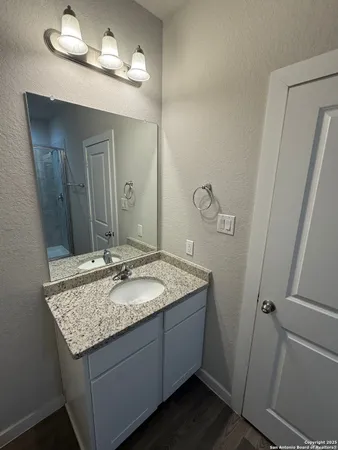 a bathroom with a granite countertop sink and a mirror