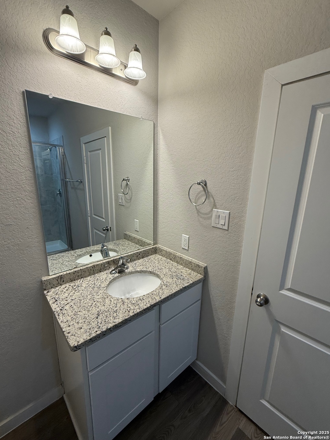 8318 Runner Cove, Unit 101 San Antonio, TX 78249 - Photo 9 of 36 a bathroom with a granite countertop sink and a mirror