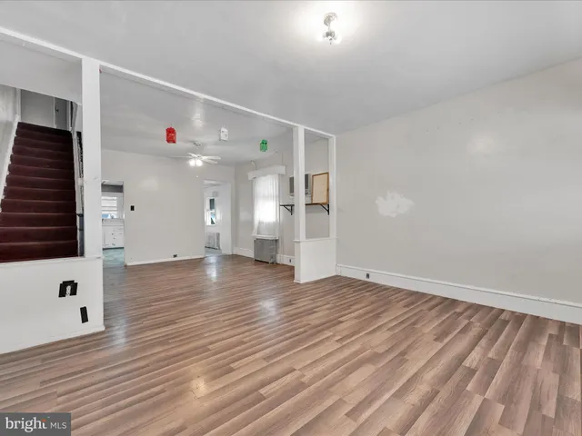 a view of an empty room with wooden floor and windows