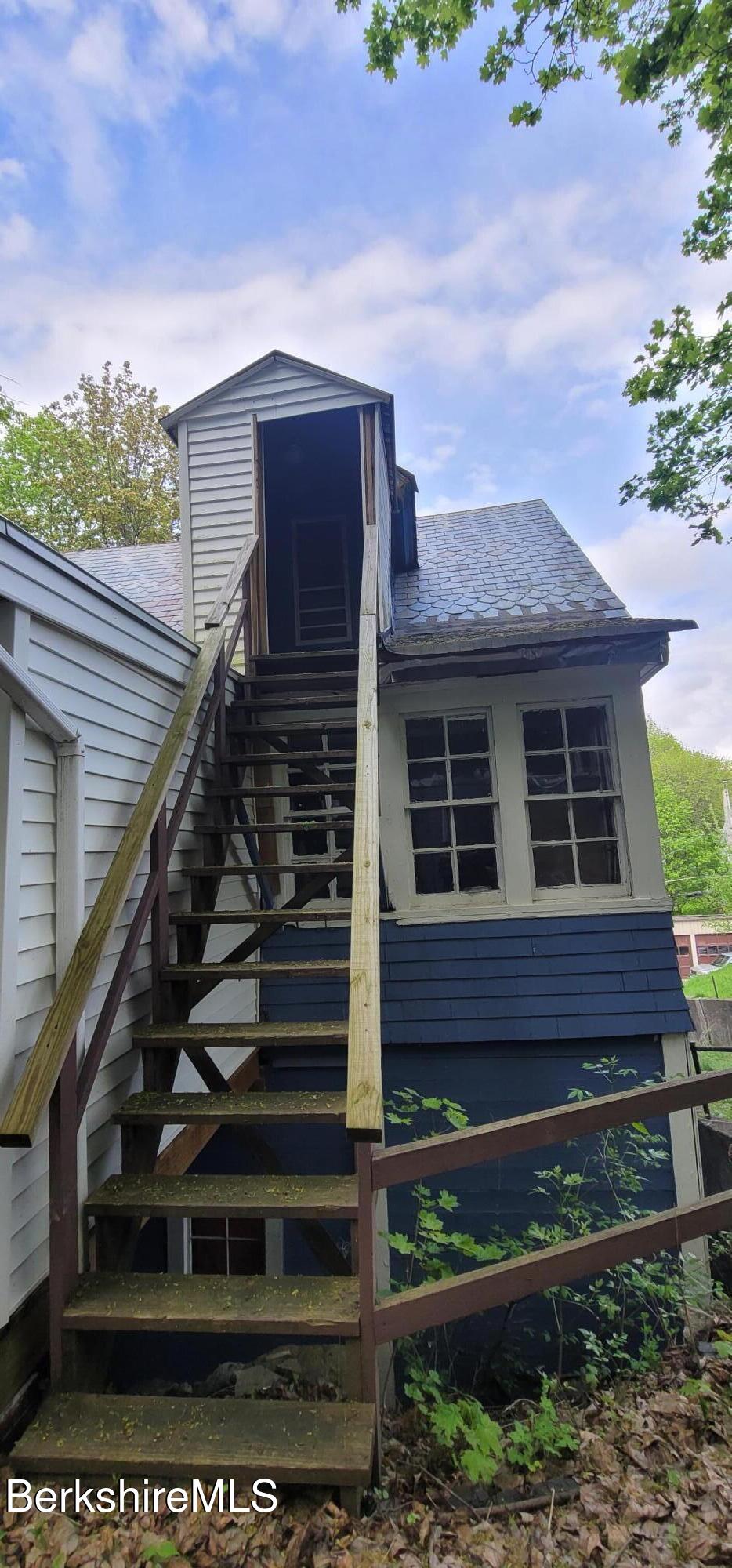 301 Walnut Street North Adams, MA 01247 - Photo 3 of 12 a view of a house with a small yard plants and wooden fence
