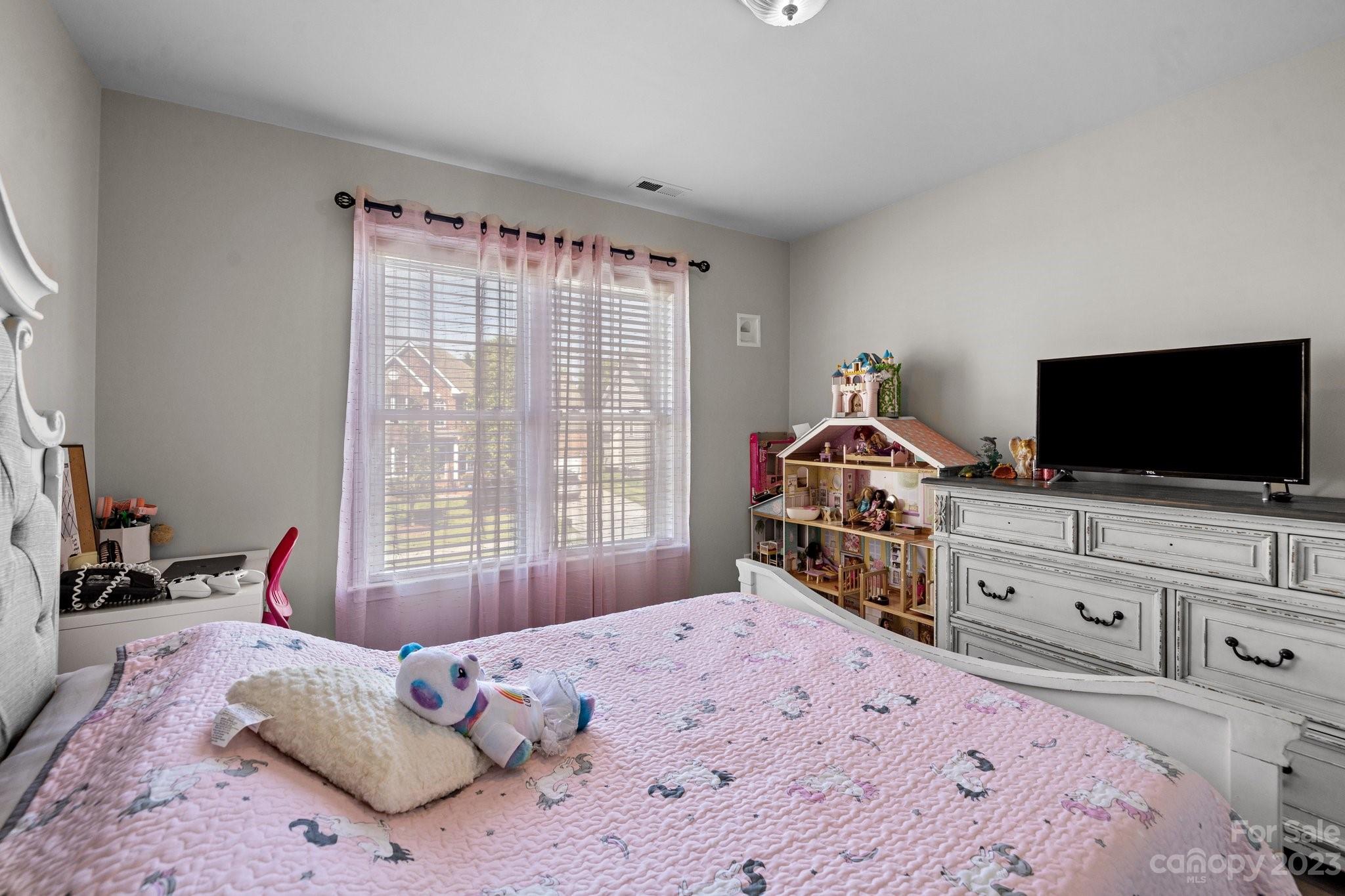 10834 Hellebore Road Charlotte, NC 28213 - Photo 17 of 41 a bedroom with a bed and a flat screen tv