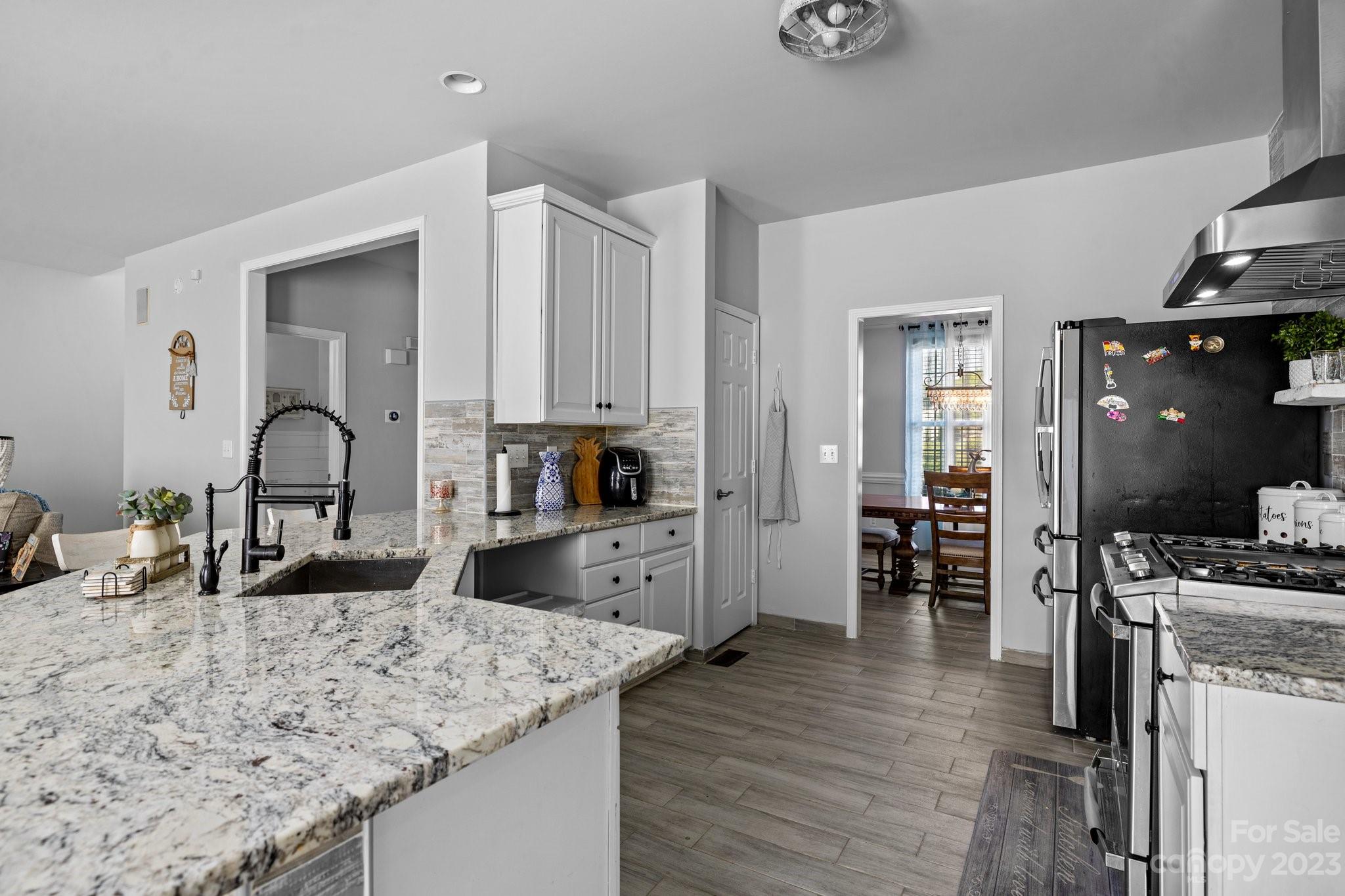 10834 Hellebore Road Charlotte, NC 28213 - Photo 8 of 41 a kitchen with granite countertop a sink cabinets and wooden floor