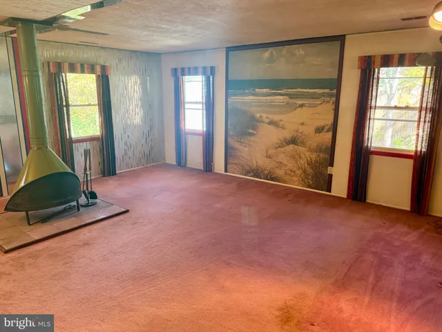 a view of an empty room with glass door and windows