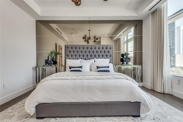 a large white bed sitting in a bedroom next to a window