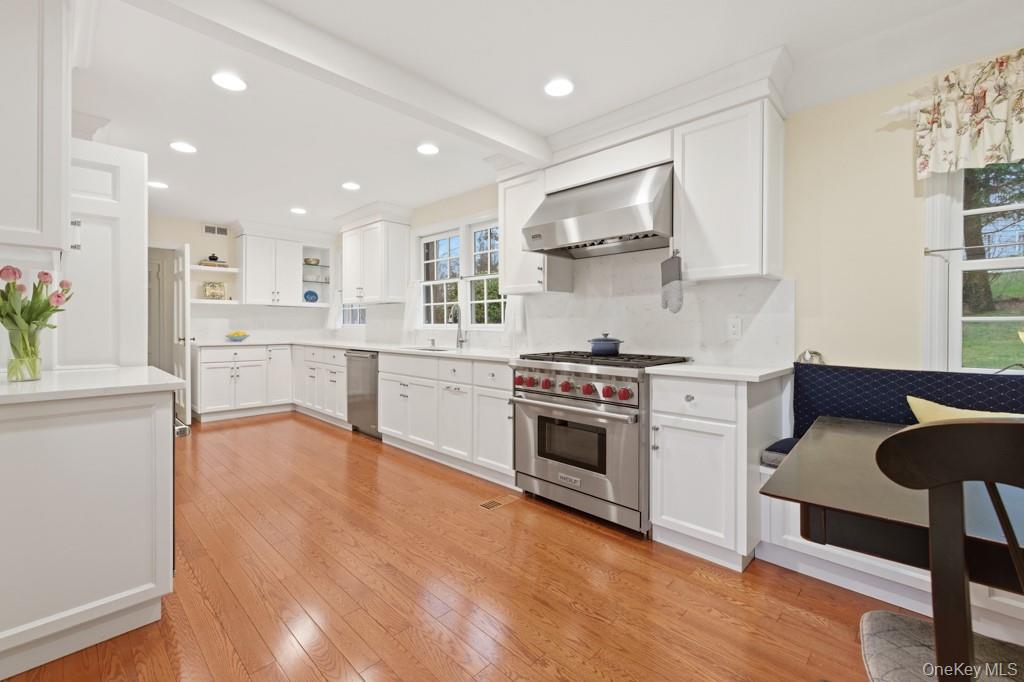 179 River Road Briarcliff Manor, NY 10510 - Photo 10 of 38 Kitchen featuring stainless steel appliances, white cabinets, light wood-type flooring, open shelves, and breakfast nook.