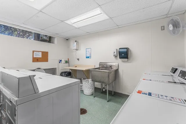 a utility room with dryer washer and a view of living room