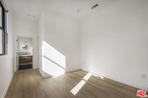 a view of empty room with wooden floor