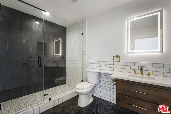 a bathroom with a sink toilet a mirror and shower