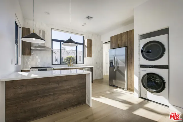 a view of a kitchen with a sink washer and dryer