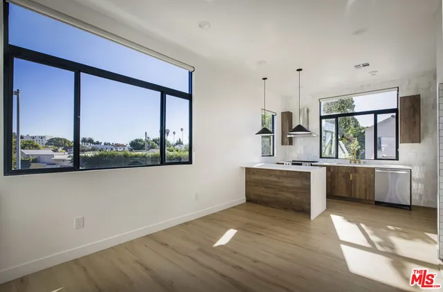 a large white kitchen with a large window