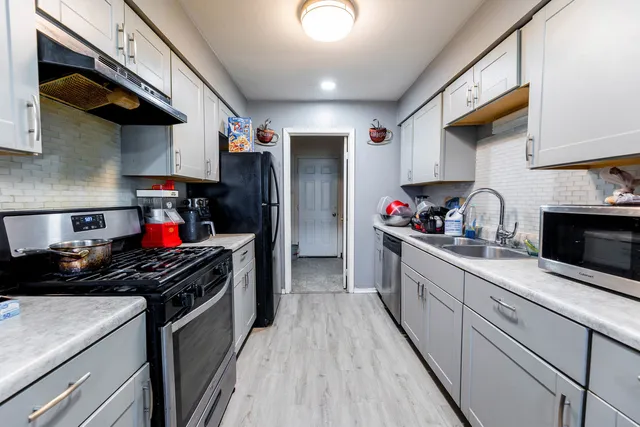 a kitchen with stainless steel appliances granite countertop a stove and cabinets
