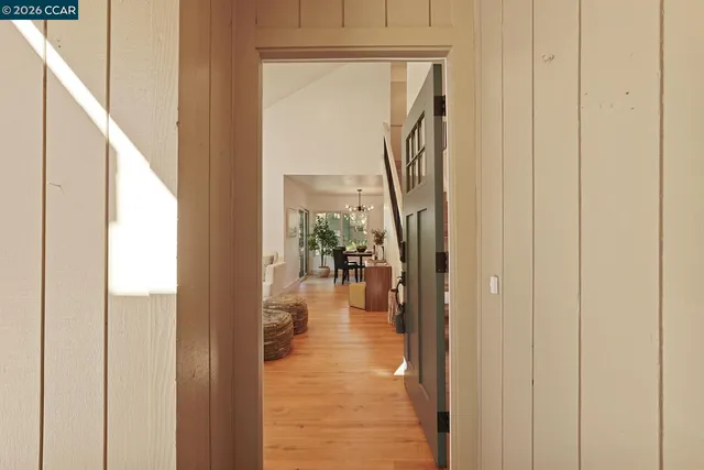 a view of a hallway with wooden floor windows and a livingroom