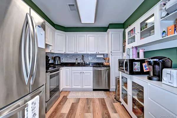a kitchen with stainless steel appliances granite countertop a refrigerator and a stove