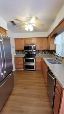 a kitchen with wooden cabinets and stainless steel appliances