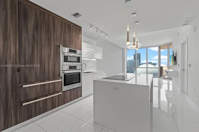 a kitchen with kitchen island a counter top space appliances and cabinets