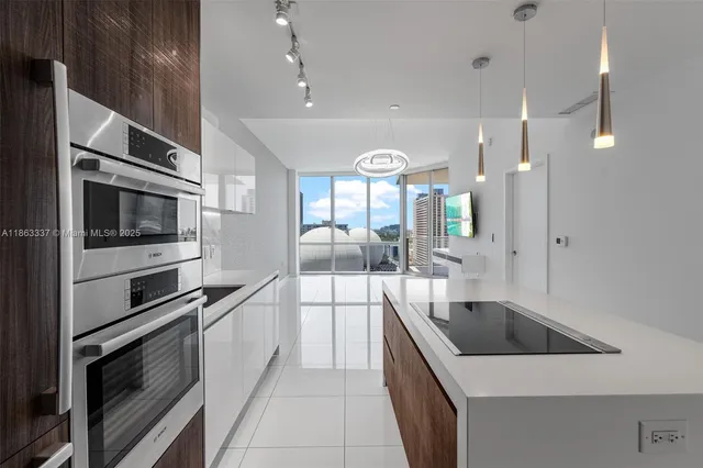 a large kitchen with a large counter top stainless steel appliances and cabinets