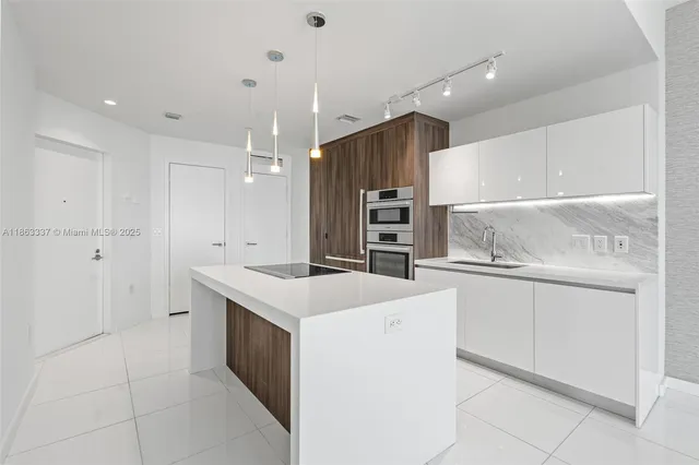 a large white kitchen with a sink a refrigerator and a stove
