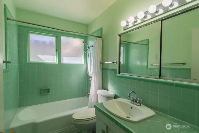 a bathroom with a sink a toilet a mirror and bathtub