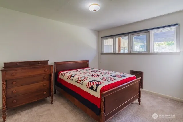 a bed sitting in a bedroom next to a window
