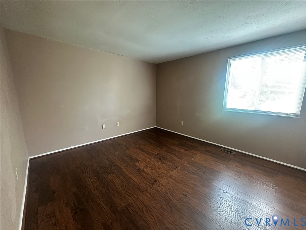 9319 Coleson Road Glen Allen, VA 23060 - Photo 11 of 39 an empty room with wooden floor and windows