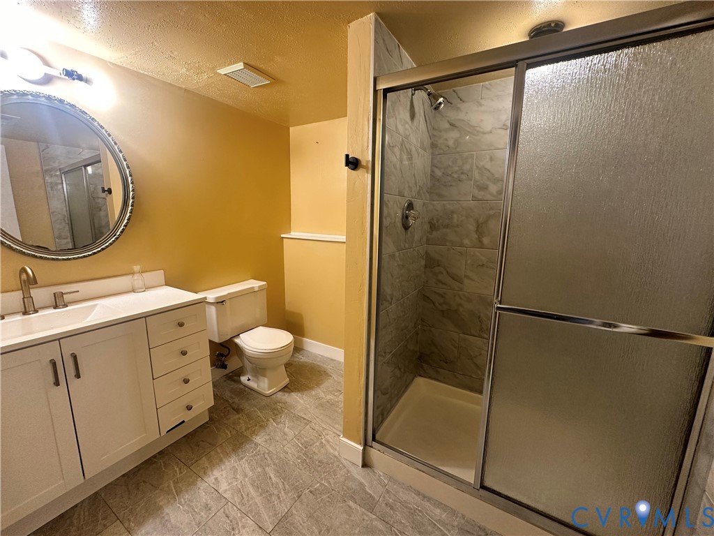 9319 Coleson Road Glen Allen, VA 23060 - Photo 31 of 39 a bathroom with a granite countertop sink toilet and shower