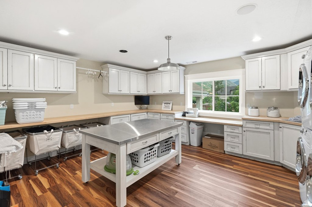 672 Perry Hollow Drive Mapleton, UT 84664 - Photo 70 of 106 DREAM laundry room! Spacious utility room featuring extensive white cabinetry, light wood-finish countertops, and wood-finish flooring