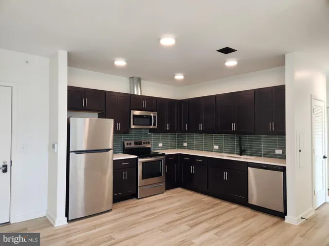 a kitchen with kitchen island a sink stainless steel appliances and cabinets