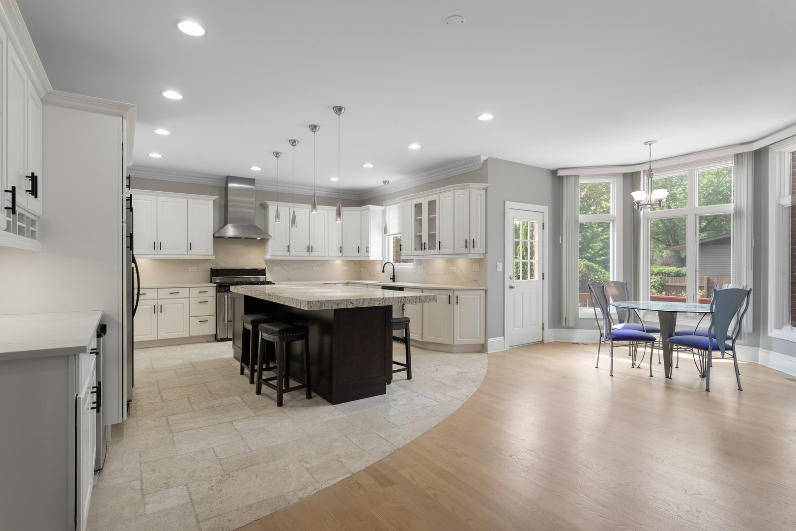 1184 Prospect Lane Des Plaines, IL 60018 - Photo 4 of 24 a kitchen with stainless steel appliances kitchen island granite countertop a refrigerator a stove a sink a dining table and chairs with wooden floor