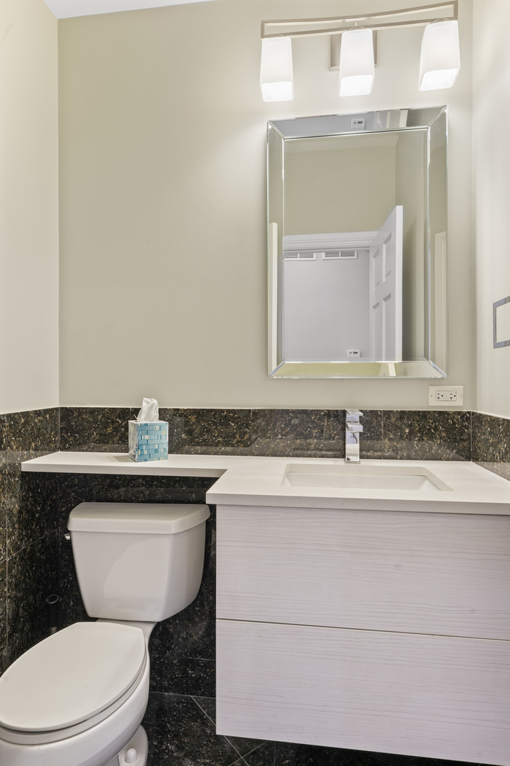 1184 Prospect Lane Des Plaines, IL 60018 - Photo 9 of 24 a bathroom with a granite countertop toilet sink and mirror