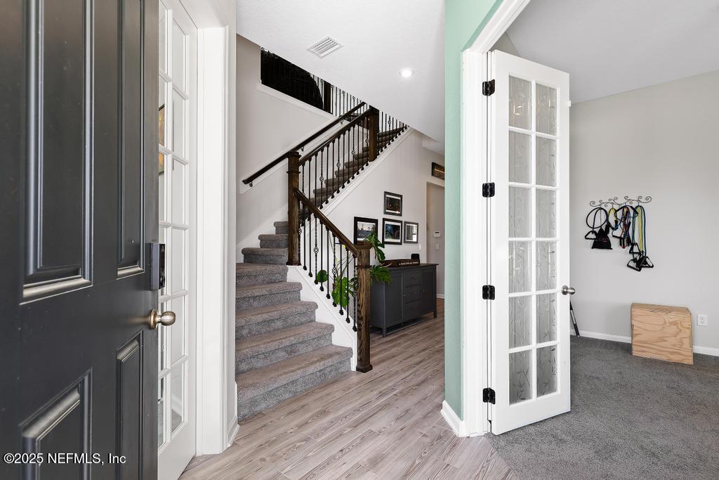 201 Oak Shadow Place St. Johns, FL 32259 - Photo 6 of 52 a view of a hallway with wooden floor and staircase