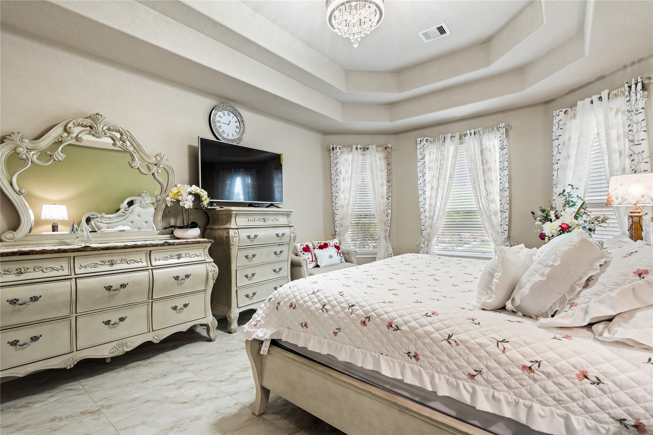 5802 Layton Meadows Lane Spring, TX 77379 - Photo 20 of 42 Master bedroom - Bay windows with sheer curtains, the bed from the foot, and the tray ceiling.