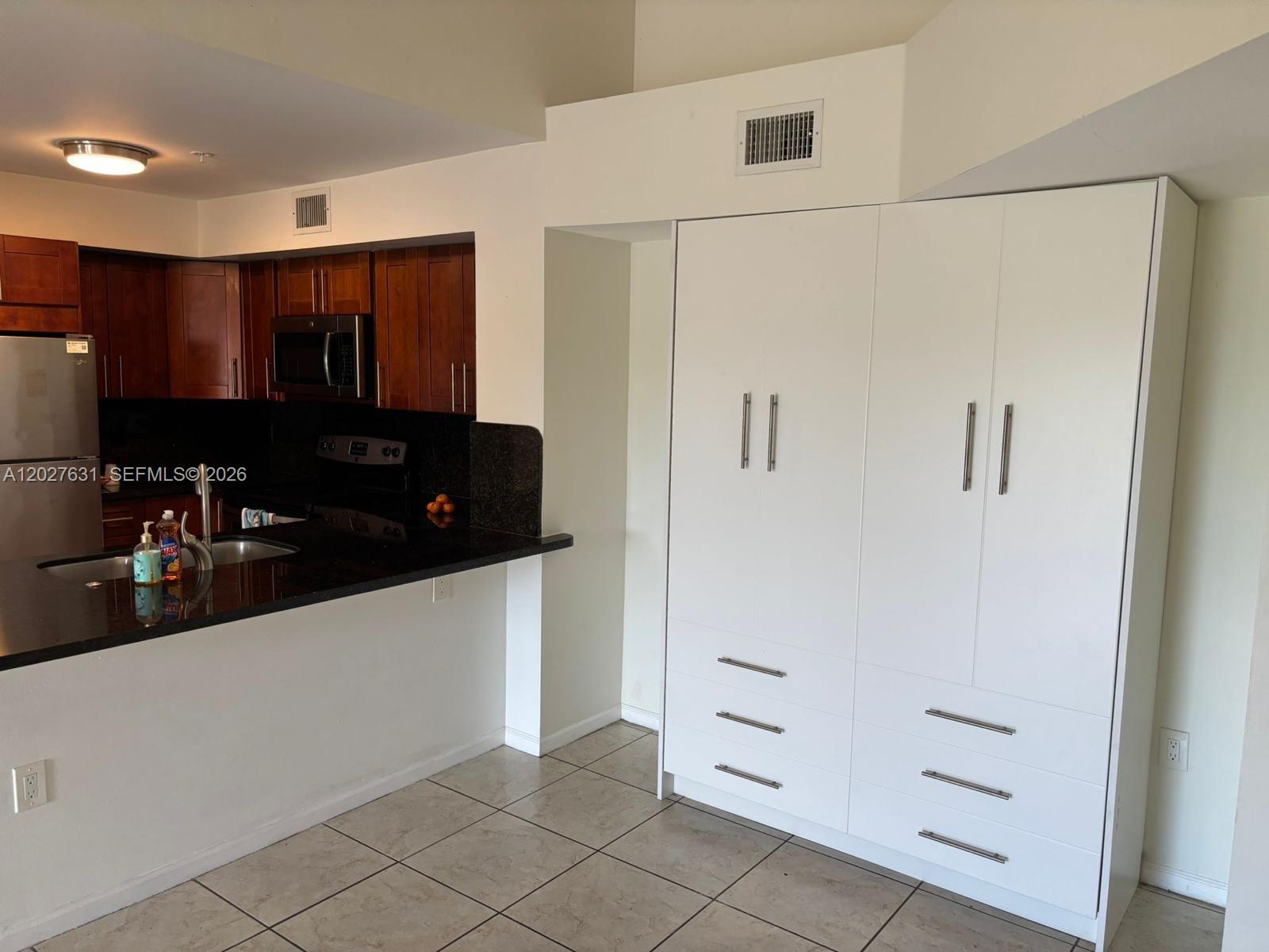 2081 Renaissance Boulevard, Unit 306 Miramar, FL 33025 - Photo 13 of 22 a kitchen with white cabinets