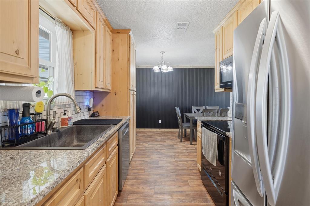 1051 Pigg Road Waxahachie, TX 75165 - Photo 11 of 40 a kitchen with stainless steel appliances granite countertop a sink stove and refrigerator