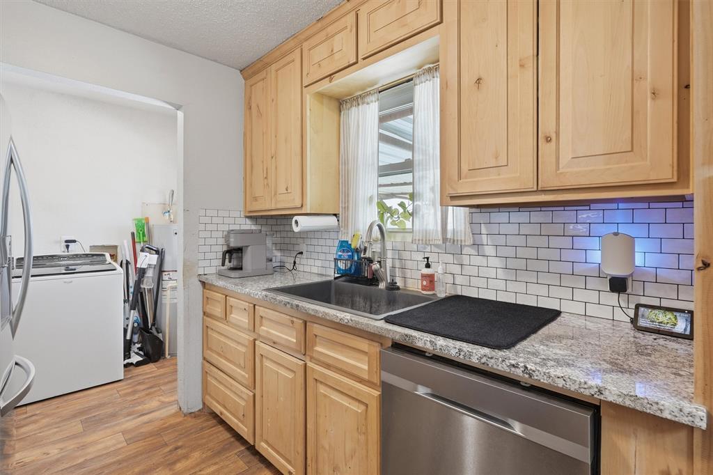 1051 Pigg Road Waxahachie, TX 75165 - Photo 12 of 40 a kitchen with stainless steel appliances granite countertop a sink a stove and a wooden cabinets