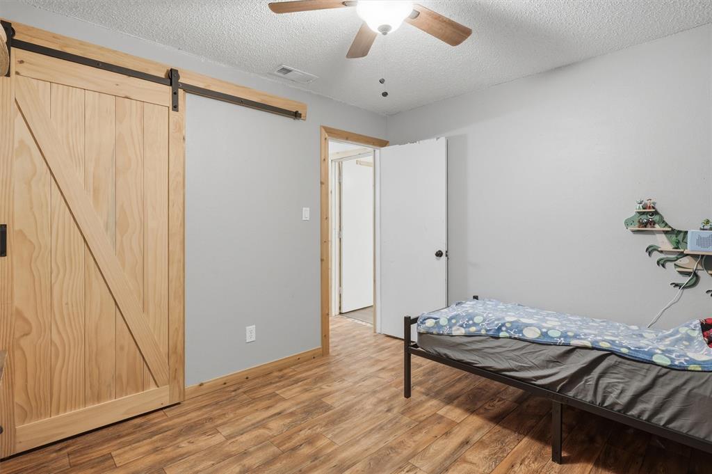 1051 Pigg Road Waxahachie, TX 75165 - Photo 20 of 40 a living room with a bed furniture and a wooden floor