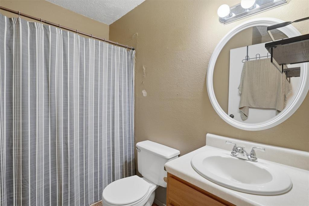 1051 Pigg Road Waxahachie, TX 75165 - Photo 26 of 40 a bathroom with a sink a toilet and a mirror