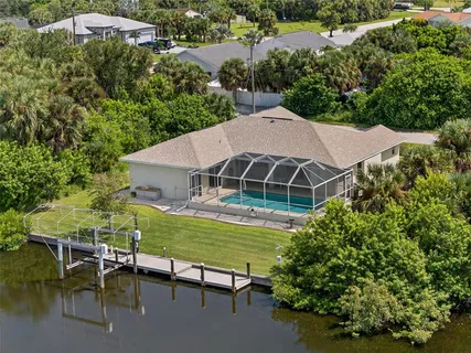 an aerial view of a house with table and chairs under an umbrella