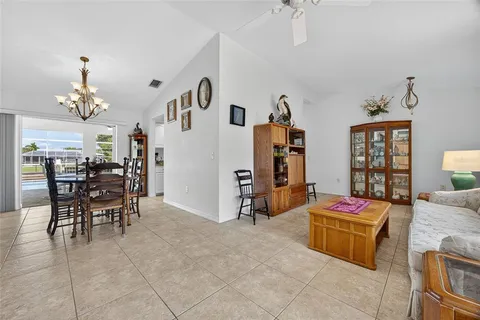 a living room with furniture a dining table and chairs with wooden floor