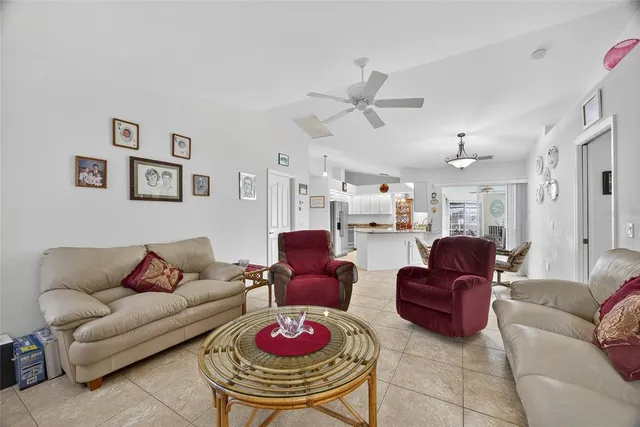 a living room with furniture kitchen view and a chandelier