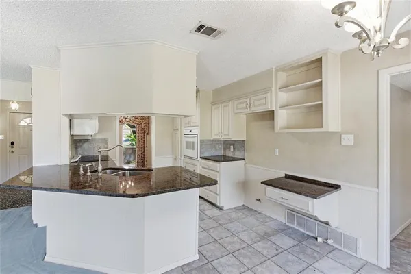 a kitchen with granite countertop a sink and cabinets