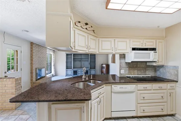 a kitchen with white cabinets and window